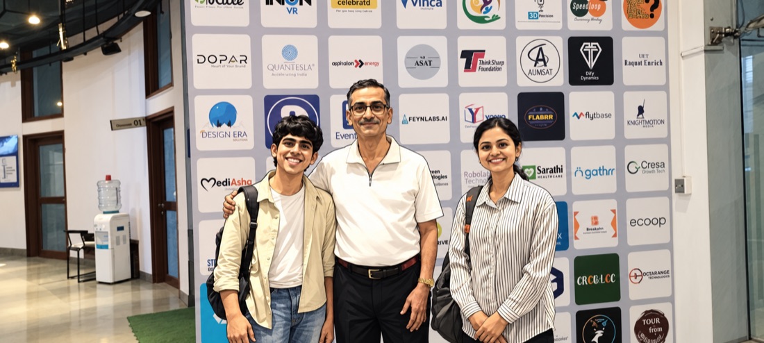 Standing in front of a wall of startup logos at COEP BHAU Institute